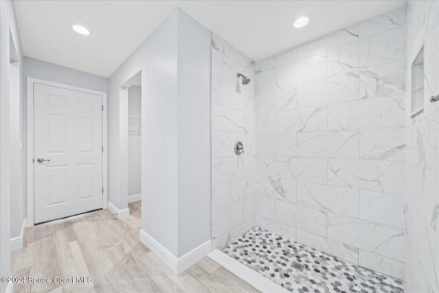 bathroom featuring wood-type flooring and tiled shower