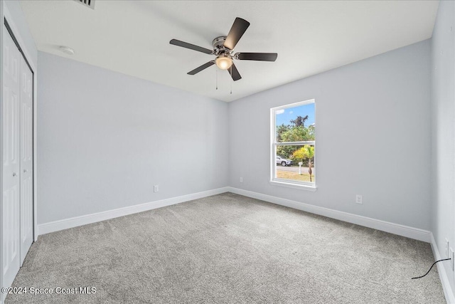 unfurnished bedroom featuring carpet flooring, a closet, and ceiling fan