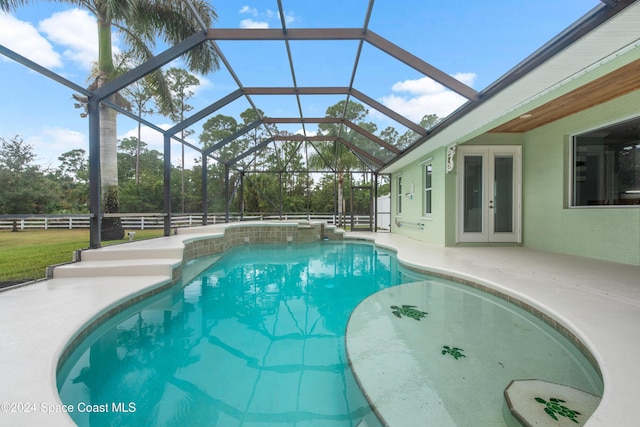 view of swimming pool with glass enclosure, a patio area, and french doors