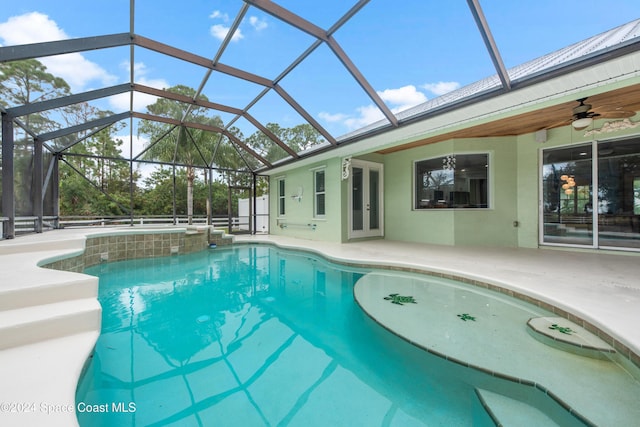 view of pool featuring glass enclosure, ceiling fan, a patio area, and french doors