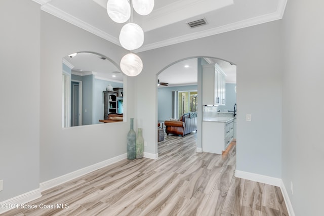 interior space with crown molding, light hardwood / wood-style flooring, and ceiling fan