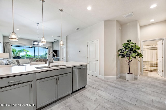 kitchen with gray cabinets, sink, stainless steel dishwasher, and decorative light fixtures