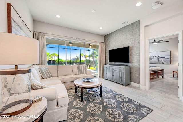 living room with light wood-type flooring and ceiling fan