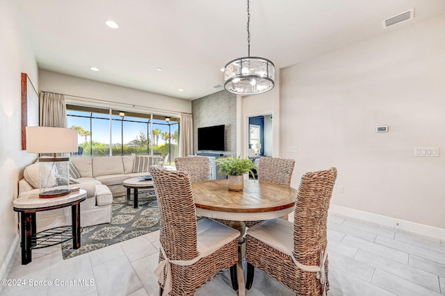 dining space featuring light tile patterned flooring and a notable chandelier