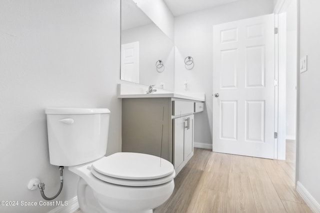 bathroom featuring hardwood / wood-style floors, vanity, and toilet