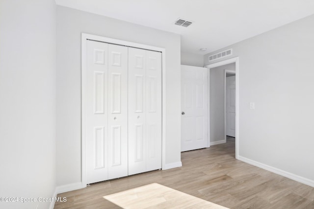 unfurnished bedroom featuring light wood-type flooring and a closet