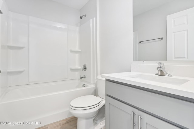 full bathroom with hardwood / wood-style floors, vanity, shower / bath combination, and toilet