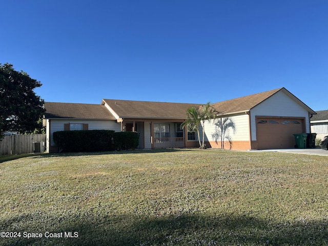 ranch-style house with covered porch, a garage, a front yard, and central AC