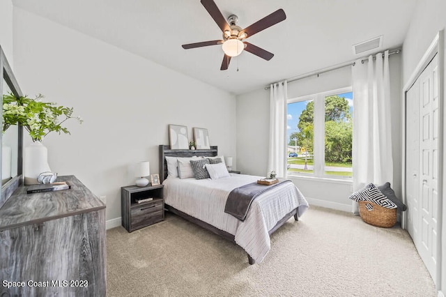 carpeted bedroom featuring ceiling fan and a closet