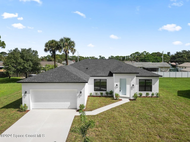 view of front of home with a front yard and a garage