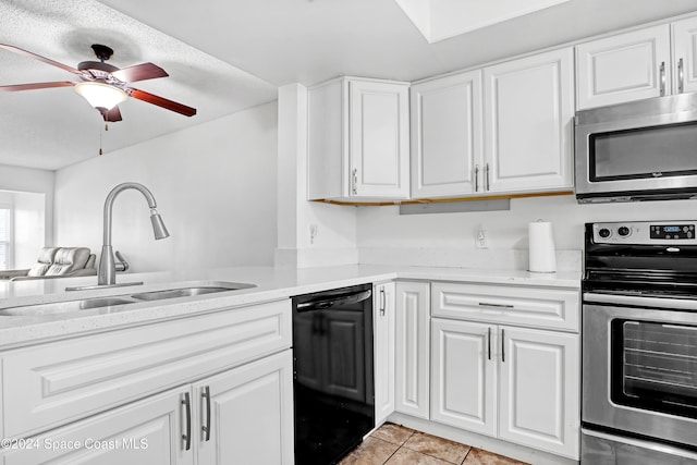 kitchen with sink, white cabinets, stainless steel appliances, and light tile patterned floors