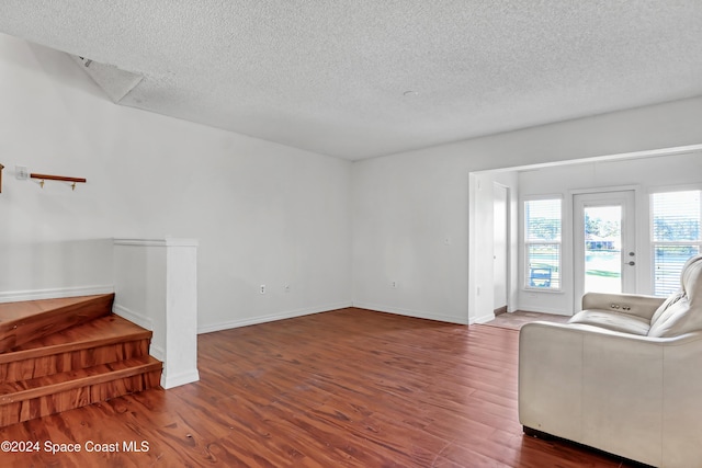 living room with a textured ceiling and dark hardwood / wood-style flooring