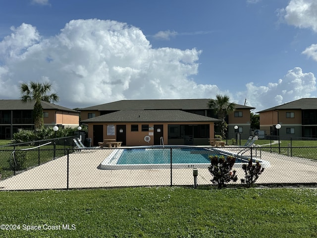 view of pool with a patio area and a lawn