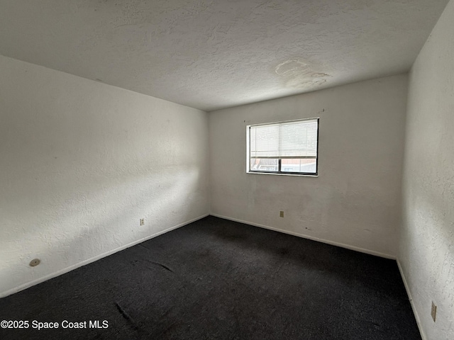 carpeted spare room with a textured ceiling