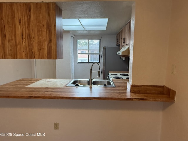 kitchen featuring stainless steel refrigerator and sink