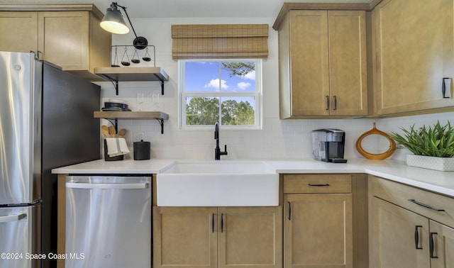 kitchen featuring appliances with stainless steel finishes, tasteful backsplash, sink, light brown cabinets, and pendant lighting