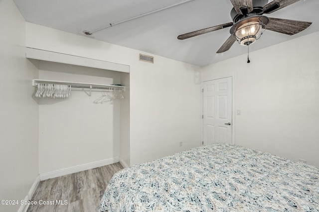 bedroom featuring ceiling fan, a closet, and wood-type flooring