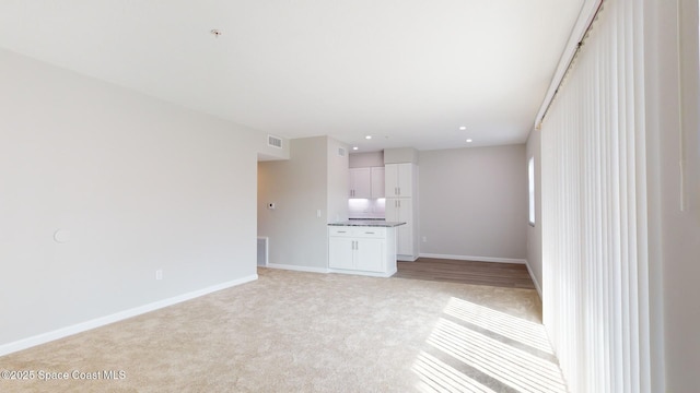 unfurnished living room featuring light colored carpet