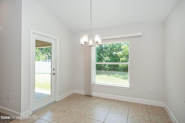 unfurnished dining area featuring light tile patterned floors, vaulted ceiling, plenty of natural light, and a notable chandelier