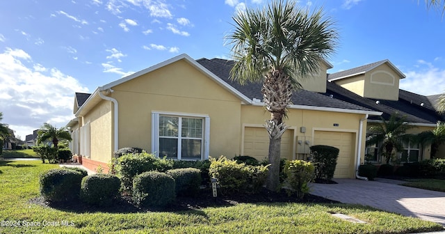 view of side of property featuring a lawn and a garage