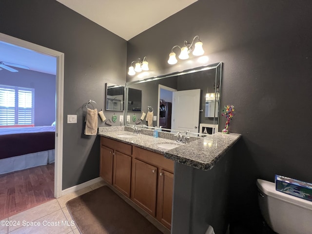 bathroom with tile patterned flooring, vanity, toilet, and ceiling fan