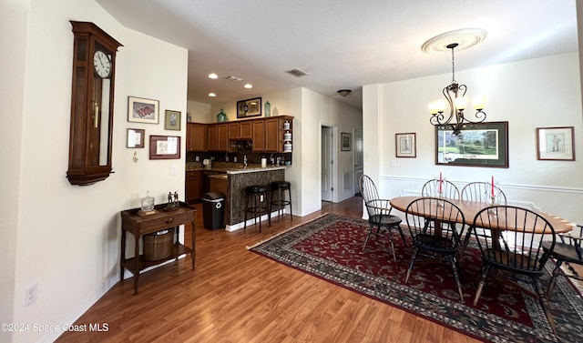 dining area featuring dark hardwood / wood-style floors and an inviting chandelier