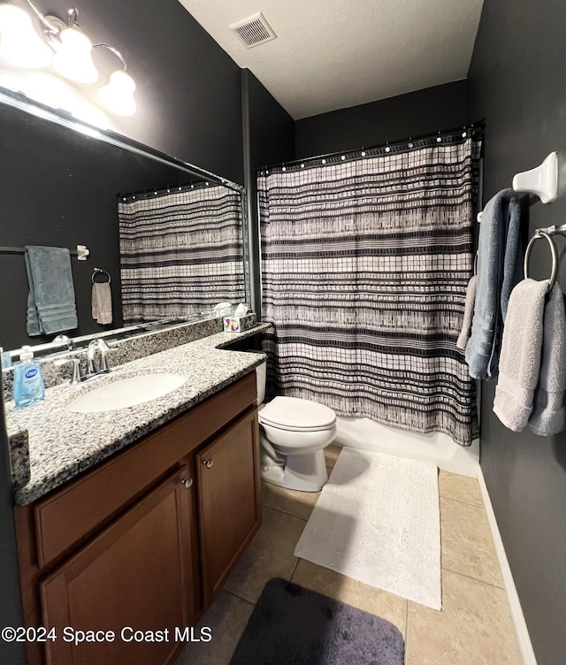 bathroom featuring tile patterned floors, walk in shower, vanity, and toilet