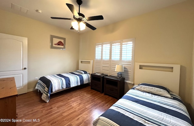 bedroom featuring ceiling fan and dark wood-type flooring