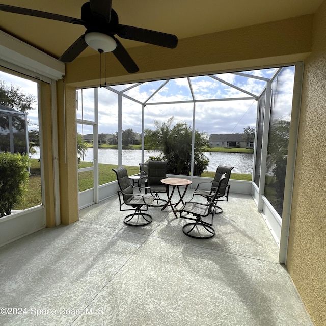 sunroom / solarium featuring a water view and ceiling fan