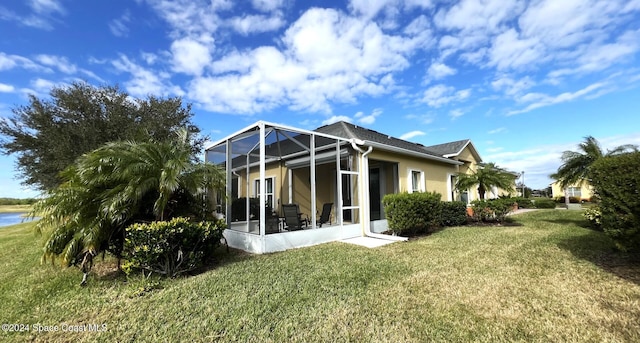 back of property featuring a yard, a water view, and a lanai