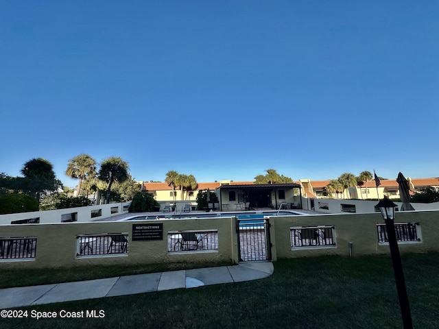 exterior space with a front lawn and a community pool