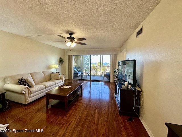 living room with ceiling fan, dark hardwood / wood-style flooring, and a textured ceiling