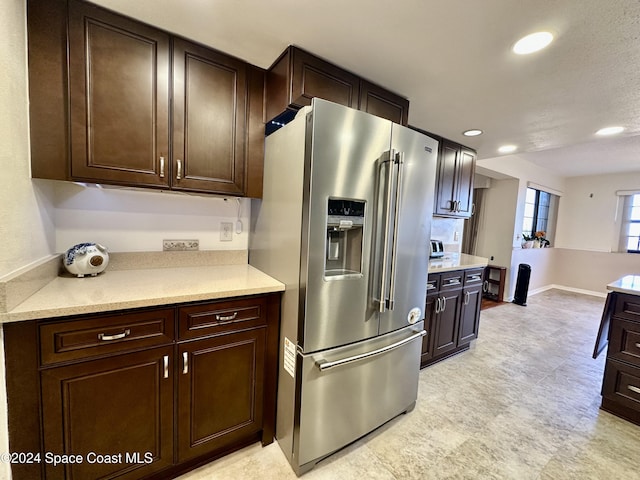 kitchen featuring stainless steel refrigerator with ice dispenser and dark brown cabinets