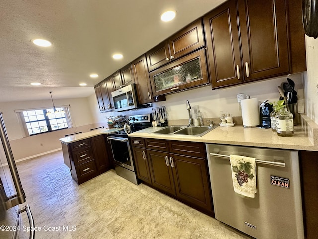 kitchen featuring lofted ceiling, sink, decorative light fixtures, appliances with stainless steel finishes, and a notable chandelier