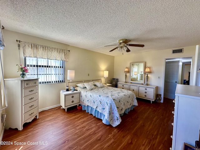 bedroom with ceiling fan, dark hardwood / wood-style flooring, and a textured ceiling