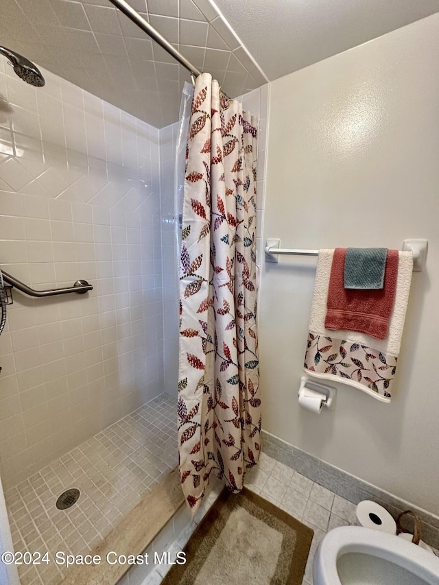 bathroom featuring a shower with curtain, tile patterned flooring, and toilet