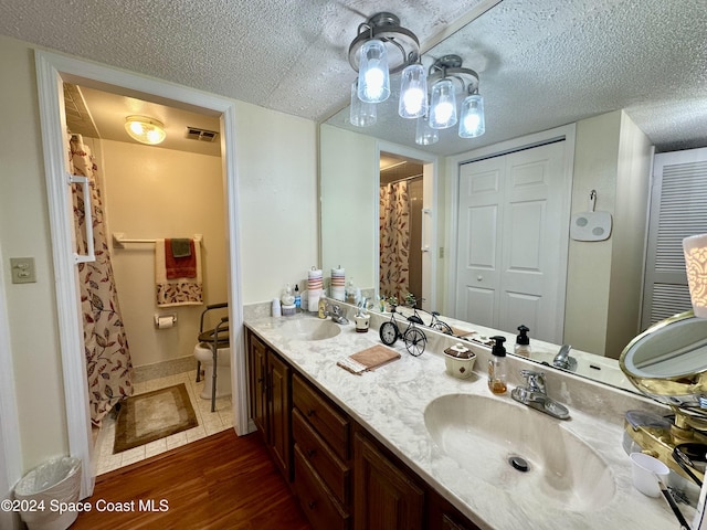 bathroom with a textured ceiling, vanity, and hardwood / wood-style flooring