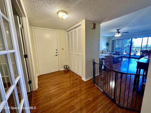 hallway with wood-type flooring and a textured ceiling