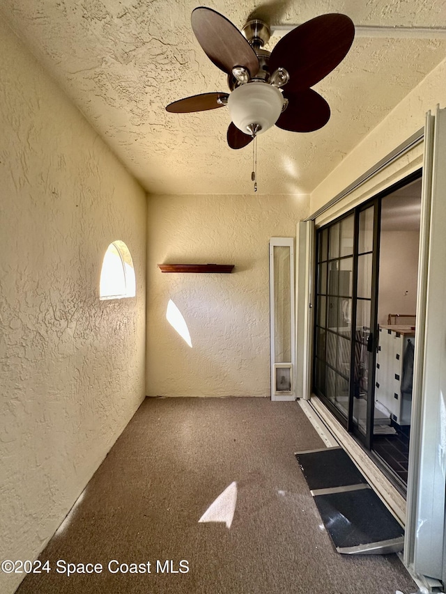 unfurnished room featuring carpet flooring, a textured ceiling, and ceiling fan