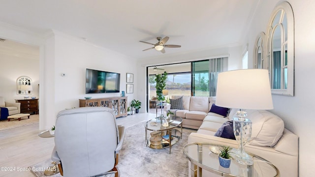 living room featuring light hardwood / wood-style floors, ceiling fan, and crown molding