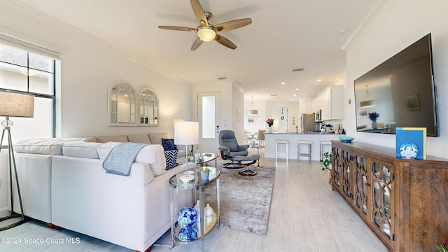 living room featuring ceiling fan and crown molding