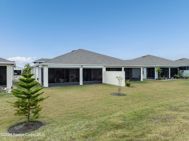 back of house with a lawn and a sunroom