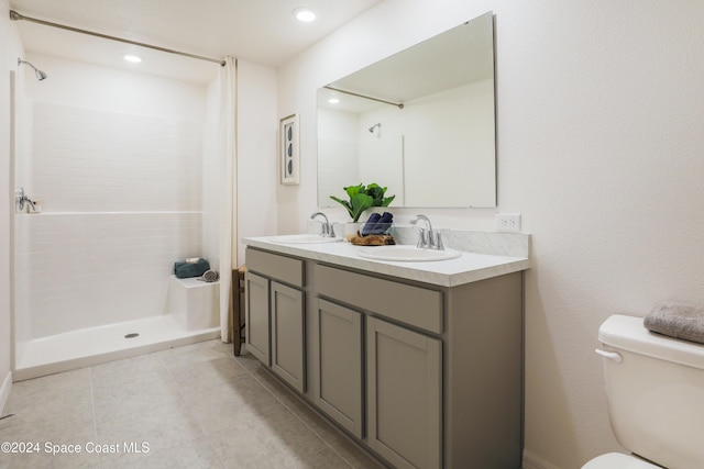 bathroom with a shower, tile patterned flooring, vanity, and toilet