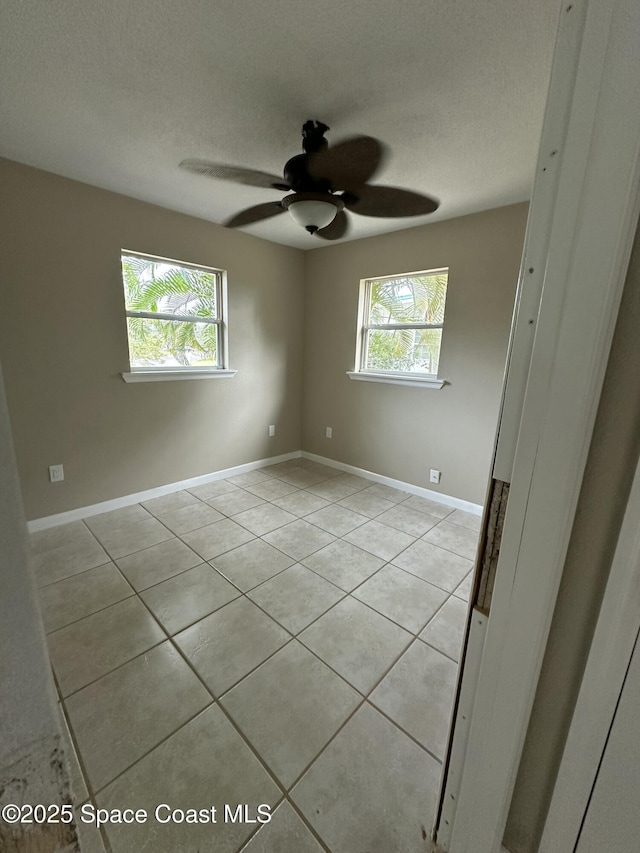 tiled empty room with a textured ceiling and ceiling fan