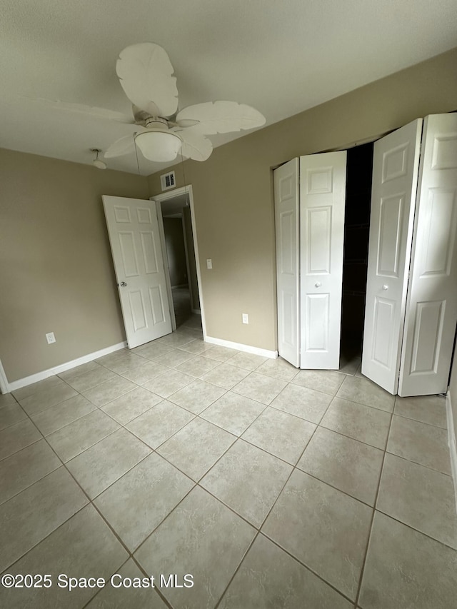 unfurnished bedroom featuring ceiling fan, light tile patterned flooring, and a closet