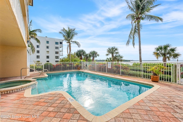 view of pool featuring a patio and a hot tub