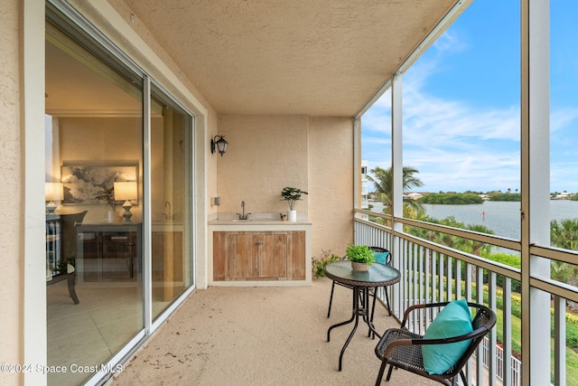 balcony featuring a water view and sink