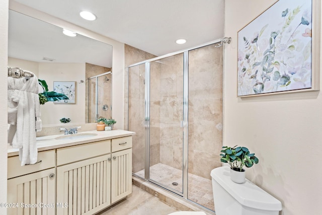 bathroom featuring vanity, toilet, and a shower with shower door