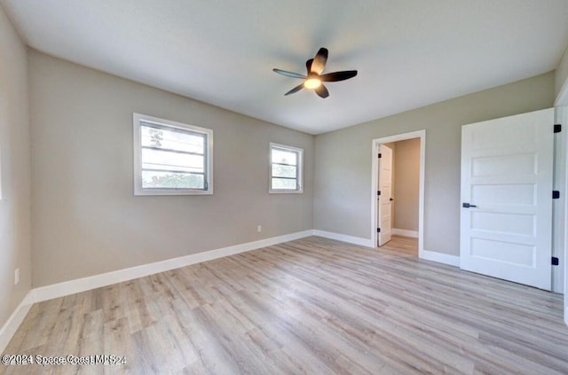 empty room with ceiling fan and light hardwood / wood-style flooring