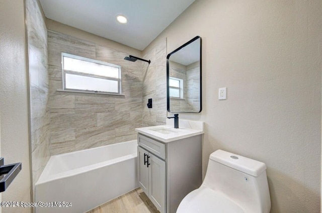 full bathroom with hardwood / wood-style flooring, vanity, toilet, and tiled shower / bath